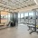 The fitness center at our apartments for rent in Raleigh, NC, featuring exercise equipment and floor to ceiling windows.