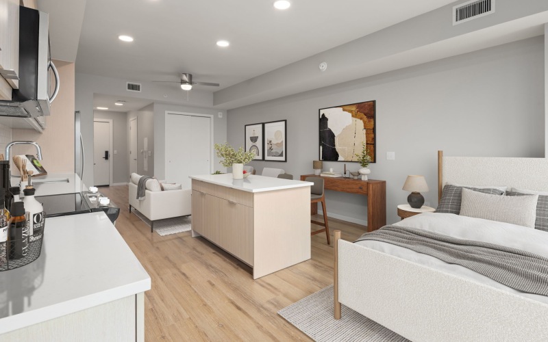 a studio with a bed and a kitchen